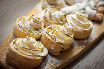Close up of delicious croissants and pastries with apples, on a wooden Board in a cafe