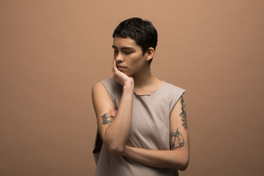 Portrait of serious nonbinary man with tattoos
