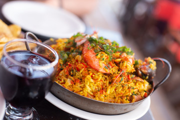 Traditional paella with rice and seafood on a plate on the table. Lifestyle