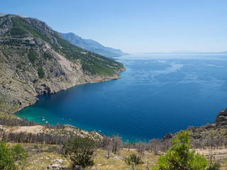 Fototapeta na wymiar Mar y montaña preciosos acantilados acabando en un agua transparente turquesa y azul en la costa croata, en verano de 2019