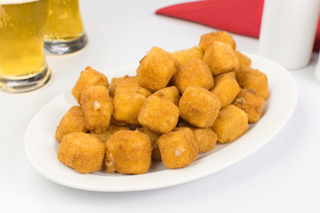Traditional Brazilian pub food provolone cheese in breadcrumbs called provolone a milanesa in a white table