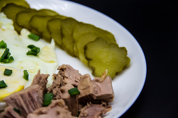 Delicious fresh tuna with eggs at the morning. Healthy and diet breakfast with tuna, eggs and vegetables on the white plate.