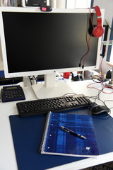 Arbeitsplatz im Homeoffice mit großem Computerbildschirm