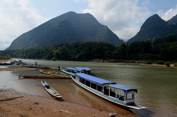 Fototapeta premium Nong Kwiaw, Laos, January 15th 2016: typical laos wooden boats waiting for tourist at the riverside