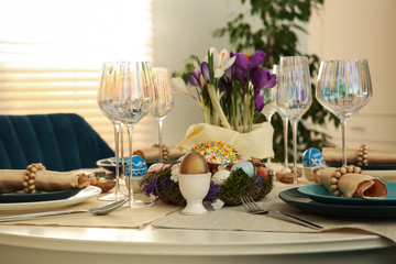 Festive Easter table setting with decorated eggs in kitchen