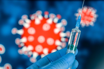 Coronavirus vaccine. hand in medical gloves holds a vaccine and a syringe against the background of the image of a coronavirus. covid-19,