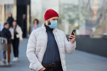 A man with a beard wearing a medical face mask to avoid the spread coronavirus (COVID-19). A guy...