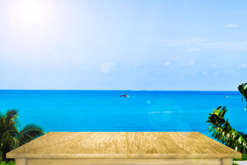 Fototapeta premium Empty wooden plank against to sea and green plants. Blank flat wooden table.