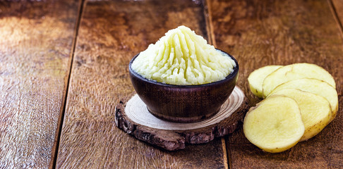 organic potato puree on rustic wooden background.