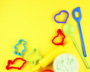 Colorful baking pans for Christmas gingerbread on a yellow background