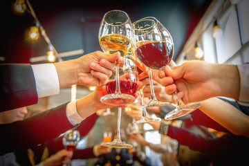 Clinking glasses with alcohol and toasting, party.