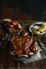 whole chicken, turkey, baked with vegetables in a rustic style, on a vintage table and vintage bowl with apples, retro style