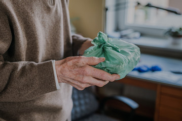Cheerful senior holding home-delivered meal, quarantine during pandemic Covid-19