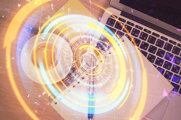 Technology hologram drawing over computer on the desktop background. Top view. Double exposure. Tech concept.
