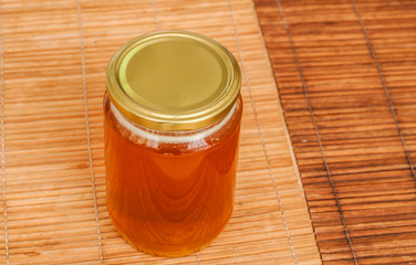 Glass honey, bee, organic, yellow, sticky, sugar, nature, background, glass, pot, nutrition, honeycomb, health, container, insect, eating, curative, sweet, jarjar full of bee honey closeup on reed mat