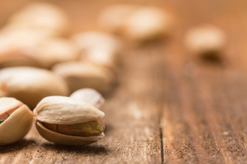 Fototapeta na wymiar extreme closeup of pistachio seeds backlit on a wooden background 