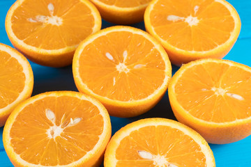 Fresh organic oranges halves fruits on blue wooden background