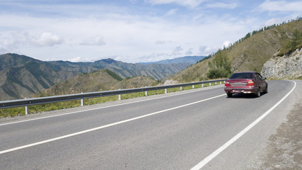 An old car on an asphalt road in the mountains. Traveling by car