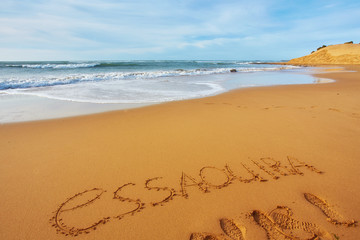 City name Essaouira written in the sand on the ocean coast