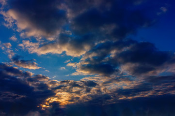 Fototapeta premium The sky at sunset. Cumulus clouds lit by the rays of the setting sun.