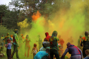 People throw up green and yellow holi paints. Holi festival of colors. Multi-colored powder in the...