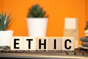 Wooden blocks with the word Ethic. Defending, systematizing and recommending concepts of right and...