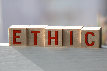 Wooden blocks with the word Ethic. Defending, systematizing and recommending concepts of right and...