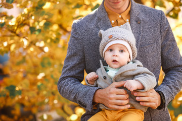 a young son is sitting in the arms of a young father