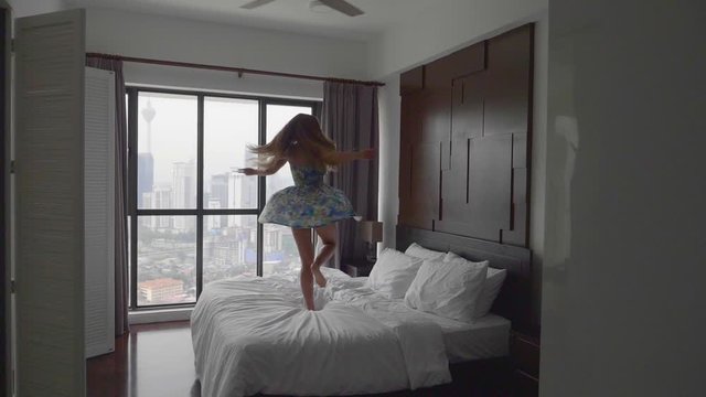 Happy Woman Jumping on the Bed
