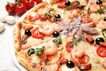 Tasty fresh pizza with seafood on table, closeup