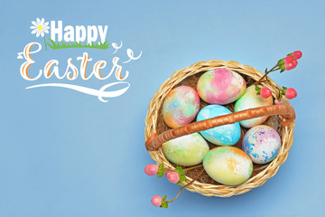 Basket with beautiful eggs and text HAPPY EASTER on color background