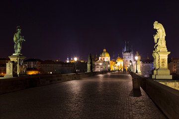 Night colorful Prague Old Town with Bridge Tower and St. Francis of Assisi Cathedral from Charles Bridge with its baroque Statues without People at the time of Coronavirus, Czech republic