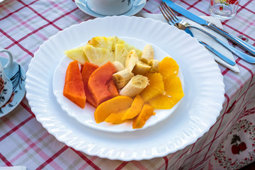 Papaya, banana, mango, pineapple, and orange in a plate. Traditional breakfast in Cuba