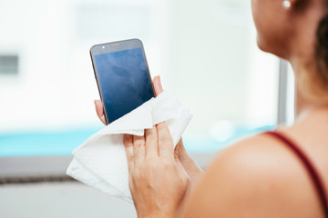 Cleaning smartphone to prevent coronavirus contamination. Precaution against Covid-19
