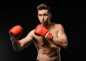 Fototapeta na wymiar Handsome young boxer on dark background