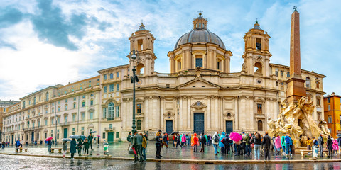 Obraz premium Rome, Italy. Sant Agnese in Agone baroque Church and Fountain of Four Rivers (Fontana Dei Quattre Fiumi) obelisk in Piazza Navona Square. Tourists visit ancient Roman architecture.