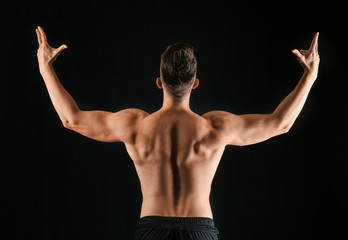 Fototapeta na wymiar Sporty man on dark background, back view