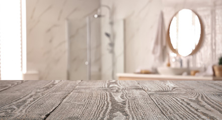 Fototapeta na wymiar Empty wooden table and blurred view of stylish bathroom interior