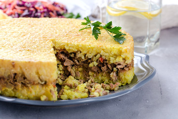 Rice dish with meat in the form of a cake, daily menu, a hearty lunch or dinner, close up on the table