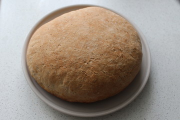 Fresh bread baked in the oven is on the table. The concept of cooking delicious and healthy food at home.