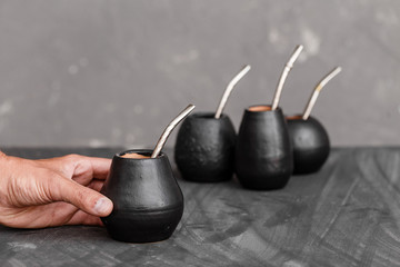 A man sharing Yerba Mate tea in gourd with sipped metal straw.