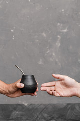 A man sharing Yerba Mate tea in gourd with sipped metal straw.