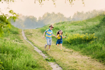 Obraz premium happy children run on the nature in the countryside, brother and sister in the meadow.