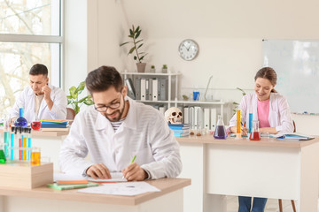 Obraz premium Young people at chemistry lesson in classroom