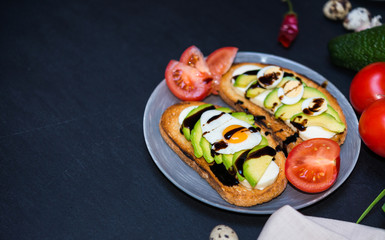 Healthy food. Avocado Sandwich and Vegetables. Toast with White Soft Cheese, Sliced Avocado, Quail Fried and Boiled Eggs Poured Balsamic Sauce for Healthy Breakfast or Snack