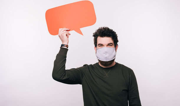 Photo of man with facial mask holding speech bubble over white background