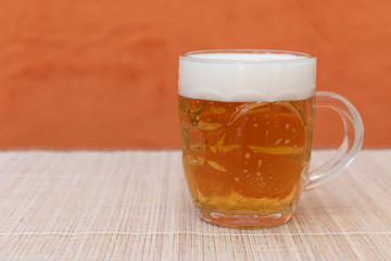 Jarra de cerveza sobre fondo naranja