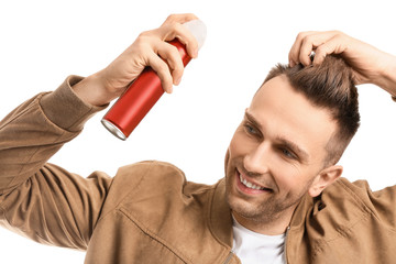 Handsome young man with hair spray on white background