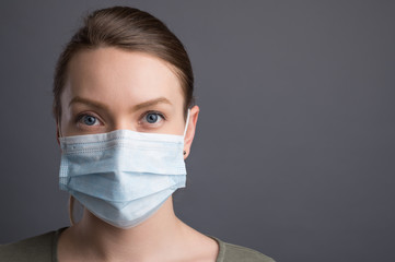 Coronavirus,covid19 girl in a mask on a gray background. The title is about an outbreak of a coronavirus virus in China, an illness. Epidemic and Pandemic: News Headlines and Media