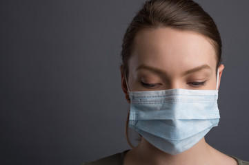 Epidemic and pandemic. Girl in a medical mask on a black background with space for an inscription. Coronavirus